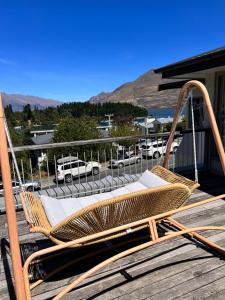 a swinging chair on a deck with a view of a parking lot at Moon House in Queenstown
