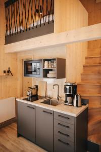 a kitchen with a sink and a stove at Wiesenglück Tiny House Hotel in Heilbad Heiligenstadt