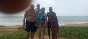 a group of people standing next to the ocean at Sea Bay Resort in Wennappuwa