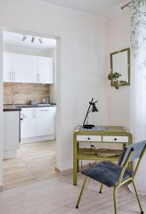 a desk and a chair in a room with a kitchen at Osiedle Zwycięstwa Chic Studio in Poznań