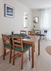 a dining room with a wooden table and chairs at Osiedle Zwycięstwa Chic Studio in Poznań