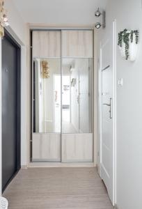 a pivot door in a hallway with a mirror at Osiedle Zwycięstwa Chic Studio in Poznań