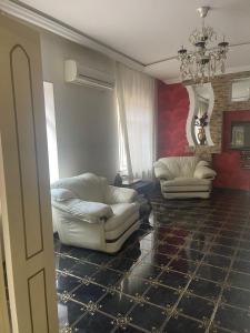 - un salon avec deux chaises blanches et un lustre dans l'établissement Luxury villa by the sea, à Baku
