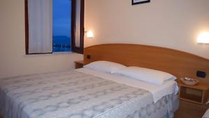 una camera da letto con un grande letto con una grande finestra di Villaggio Hydra a Marina di Casalvelino