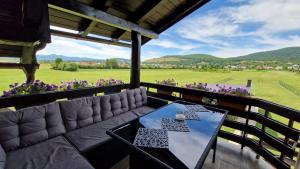 a couch and table on a balcony with a view of a field at House Boketto in Korenica