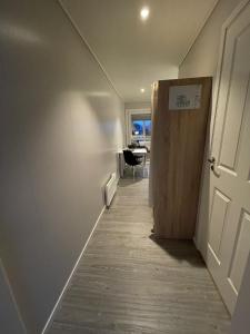 pasillo con puerta y habitación con mesa en Vestfjordgata Apartment 1 en Svolvær