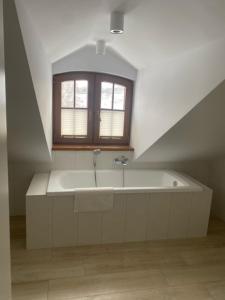 een badkamer met een bad onder een raam bij Dom przy stoku 2 in Bałtów