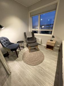 a living room with two chairs and a chair and a table at Vestfjordgata Apartment 5 in Svolvær