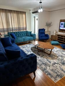 sala de estar con sofá azul y 2 sillas azules en Atasehir Rezidans, en Estambul