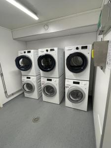 4 lavatrici e asciugatrici sono allineate in una lavanderia di Vestfjordgata Apartment 12 a Svolvær