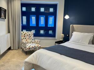 a bedroom with a bed and a chair and a window at Misk Villa - Boutique Hotel & Spa in Sidi Bou Saïd