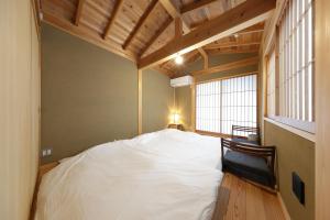 a large white bed in a room with a window at 一棟貸しの宿 寂香庵 in Kamakura