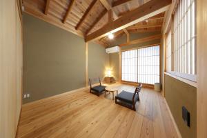 鎌倉市にある一棟貸しの宿 寂香庵の椅子2脚、テーブル、窓が備わる客室です。