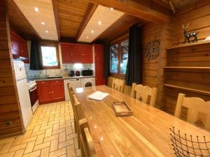 una cucina con tavolo in legno in una cabina di LE RENNE Chalet en bois au calme avec SPA Jacuzzi a La Bresse