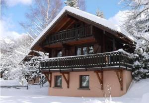 una baita con la neve sul tetto di LE RENNE Chalet en bois au calme avec SPA Jacuzzi a La Bresse