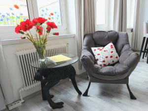維也納的住宿－Apartman Favorita，客厅配有椅子和一张带花瓶的桌子