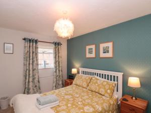 een slaapkamer met een bed en een kroonluchter bij Shell Seeker Cottage in Bridlington