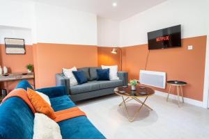 uma sala de estar com um sofá azul e uma televisão em Cohost Partners | Stylish and spacious 1Br em Newport