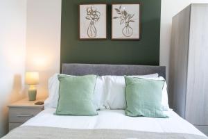 a bedroom with a bed with two pictures on the wall at Cohost Partners | Stylish and spacious 1Br in Newport