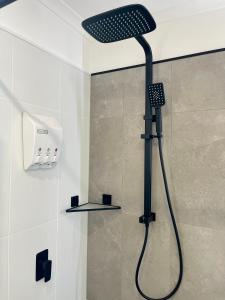 a shower with a black shower head in a bathroom at Emu Retreat B&B in Tailem Bend