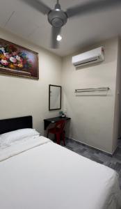 a bedroom with a white bed and a desk at 西子楼 CZI Budget Hotel Sungai Siput in Sungai Siput