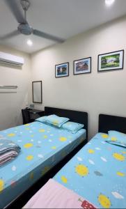 two beds sitting next to each other in a bedroom at 西子楼 CZI Budget Hotel Sungai Siput in Sungai Siput