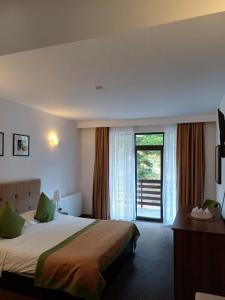 a hotel room with a bed and a large window at Apartamente Private A&L View in Sinaia