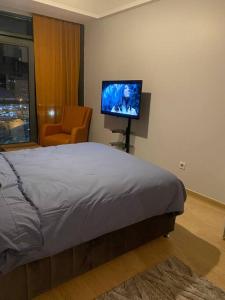 a bedroom with a bed and a flat screen tv at Atasehir rezidans in Istanbul