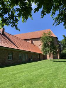 un grand bâtiment en briques avec un arbre dans la cour dans l'établissement Ferienwohnung Schmidt Haffkamp, à Grömitz