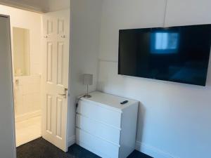 um quarto com uma televisão numa parede com um frigorífico em Circle Guest House Bed Only em Southampton