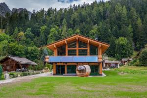 a large wooden house with a large window at Chalet Aikoa in Chamonix-Mont-Blanc