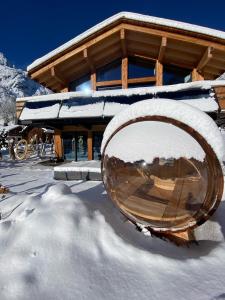 pokryty śniegiem budynek z dużym metalowym przedmiotem w śniegu w obiekcie Chalet Aikoa w Chamonix-Mont-Blanc