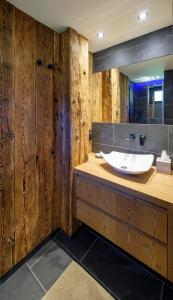 Łazienka z drewnianymi ścianami i białą umywalką w obiekcie Chalet Aikoa w Chamonix-Mont-Blanc