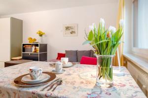 a table with plates and a vase of flowers on it at Eichhörnchens Paradies in Todtmoos