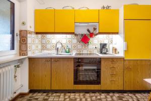 a kitchen with yellow cabinets and a sink at Eichhörnchens Paradies in Todtmoos