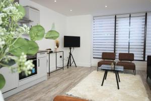 a living room with a tv and a table at Central Charming and Contemporary 2Br Apartment in Swindon