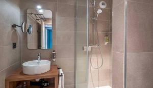 a bathroom with a shower with a sink and a shower at L'Escale Marine, The Originals Relais in Crozon