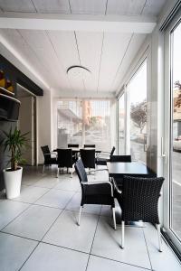 een eetkamer met tafels, stoelen en ramen bij Hotel Vienna in Gabicce Mare