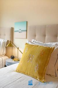 ein Schlafzimmer mit einem Bett mit einem gelben Kissen darauf in der Unterkunft Gaia Panoramic Terrace Apartment - D. Pedro V in Vila Nova de Gaia