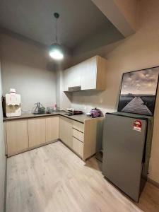 een kleine keuken met een koelkast en een wastafel bij Jesselton Quay by MS in Kota Kinabalu