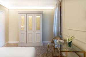 Cette chambre dispose d'une porte, d'une table et d'une chaise. dans l'établissement San Vio Palace Luxury Apartments, à Venise