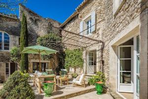 a patio with an umbrella and a table and chairs at Le Clos de Gordes in Gordes