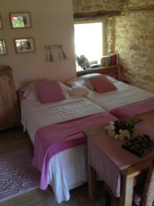 a bedroom with two beds and a table at Lo Petit Cretsou in Simeyrols