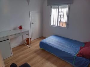 a bedroom with a bed and a desk and a window at Hogar con encanto en Segorbe in Segorbe