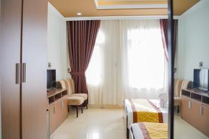 una camera ospedaliera con due letti e una televisione di Dat Anh Hotel a Hue
