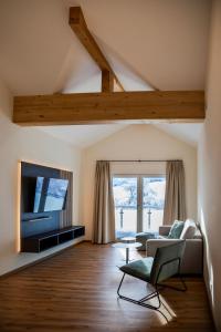 uma sala de estar com um sofá e uma televisão em Das Steinach em Pfronten