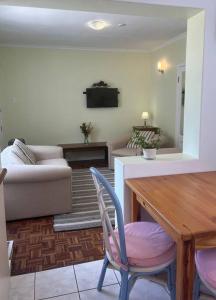 a living room with a table and a couch at Harbour Cottage Kalk Bay in Cape Town