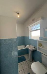 a bathroom with a toilet and a sink and a tub at Harbour Cottage Kalk Bay in Cape Town