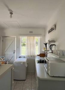 a white kitchen with a sink and a window at Harbour Cottage Kalk Bay in Cape Town