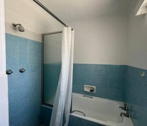 a bathroom with a tub and a shower with a shower curtain at Harbour Cottage Kalk Bay in Cape Town